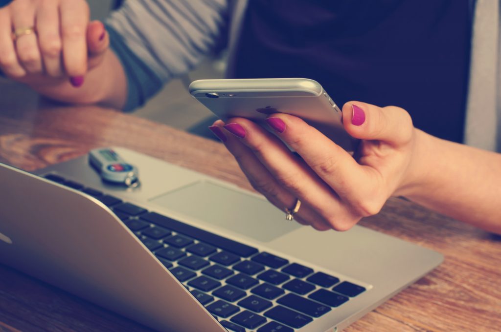 A women using phone and laptop simultaneously 